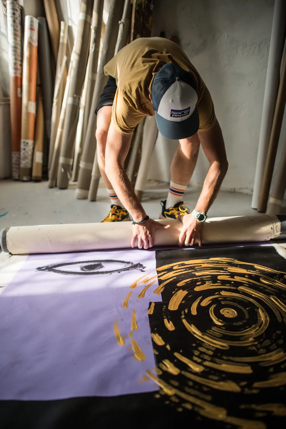 Un artista al lavoro su una tela della serie Circles of Life durante la residenza